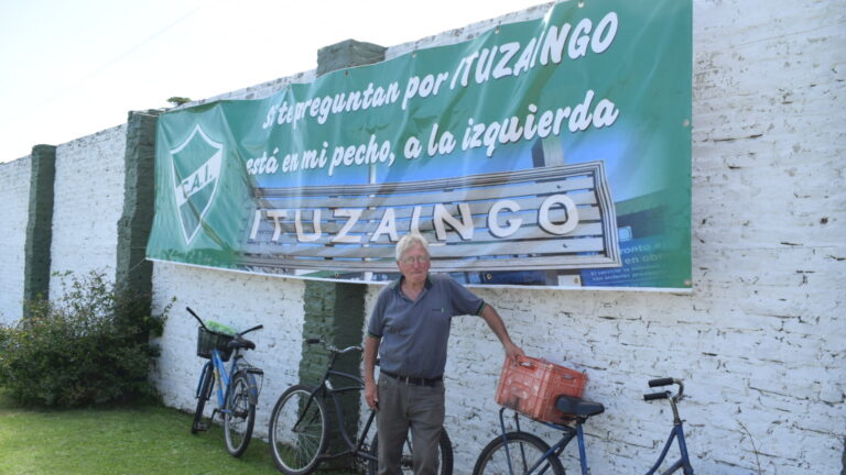 Roberto Sciolini apoyado en su inseparable bicicleta. Detrás, la bandera donde se inmortalizó su frase.