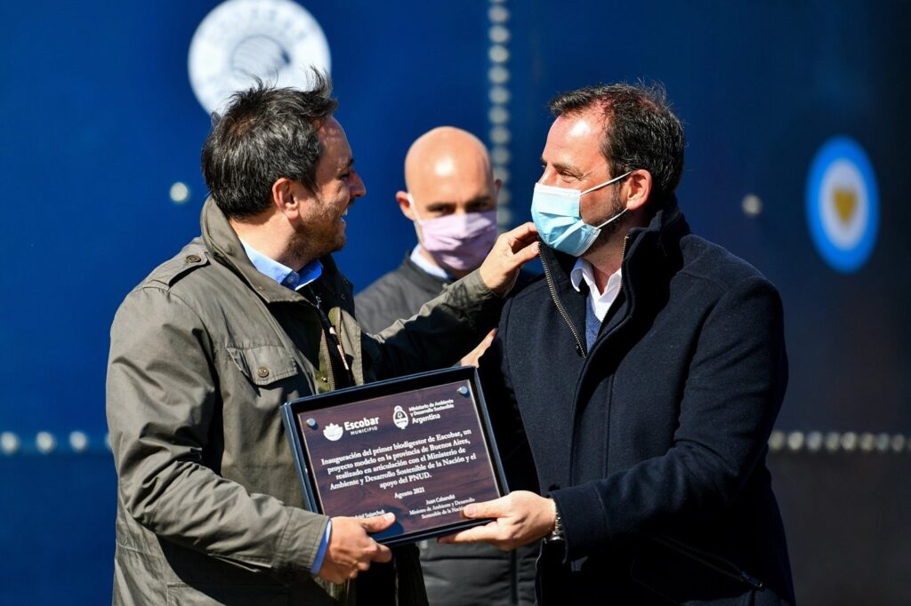 Juan Cabandié y Ariel Sujarchuk con la placa inaugural del biodigestor.
