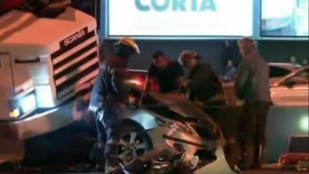 Bomberos de Vicente López trabajan en uno de los autos aplastados por el camión en la Panamericana.