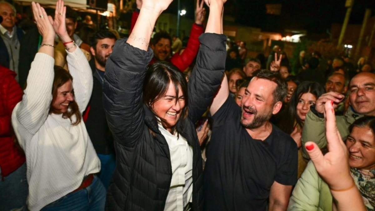El intendentes de Escobar, Ariel Sujarchuk, le levanta la mano a Laura Cejas, que encabezó la lista de concejales de Fuerza Patria.