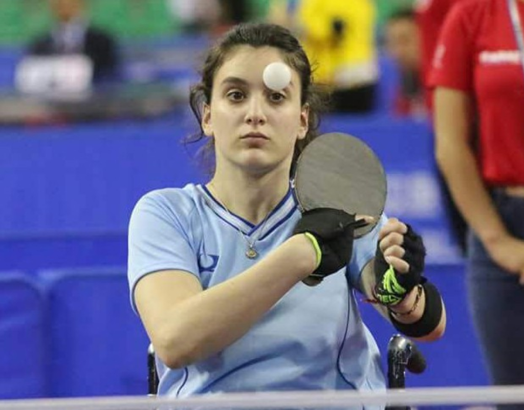 Constanza Garrone practicaba gimnasia artística en el Club Ituzaingó, donde sufrió un accidente en 2011. Quedó lisiada y luego se dedicó al tenis de mesa adaptado.